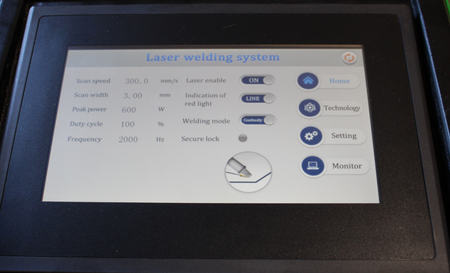 Laser welding system control panel with settings displayed on a screen.