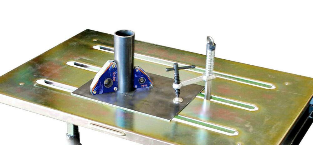 Metal welding table with tube, corner magnets, and welding clamp setup