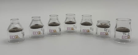 Row of clear glass EDGE welding cups with mesh diffusers on white background