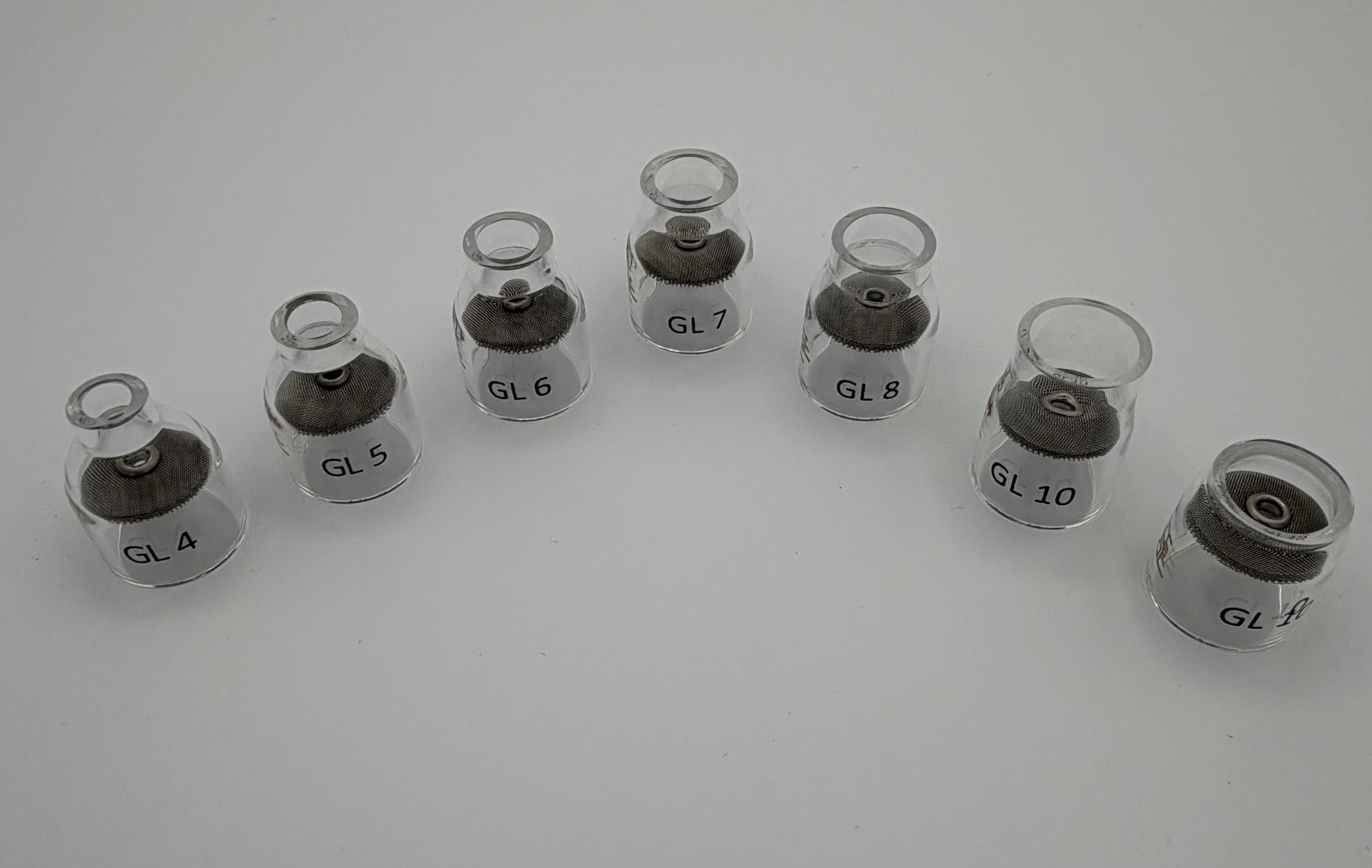 Set of clear glass TIG welding cups labeled GL4 to GL10 arranged in a curved row on white