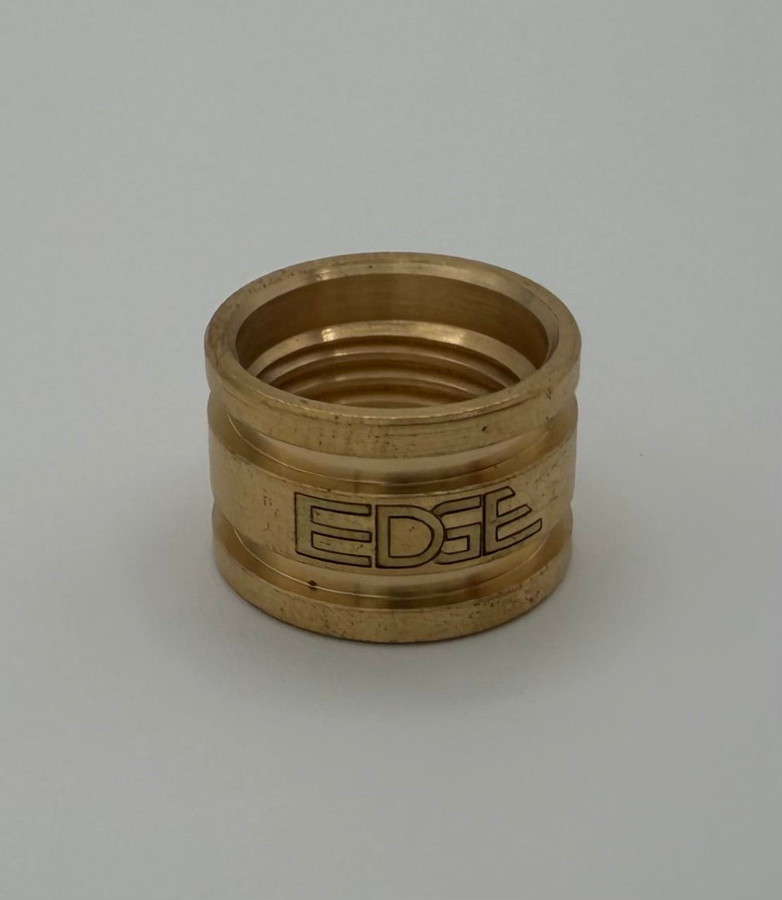 Brass welding cup adapter with engraved EDGE logo on plain background