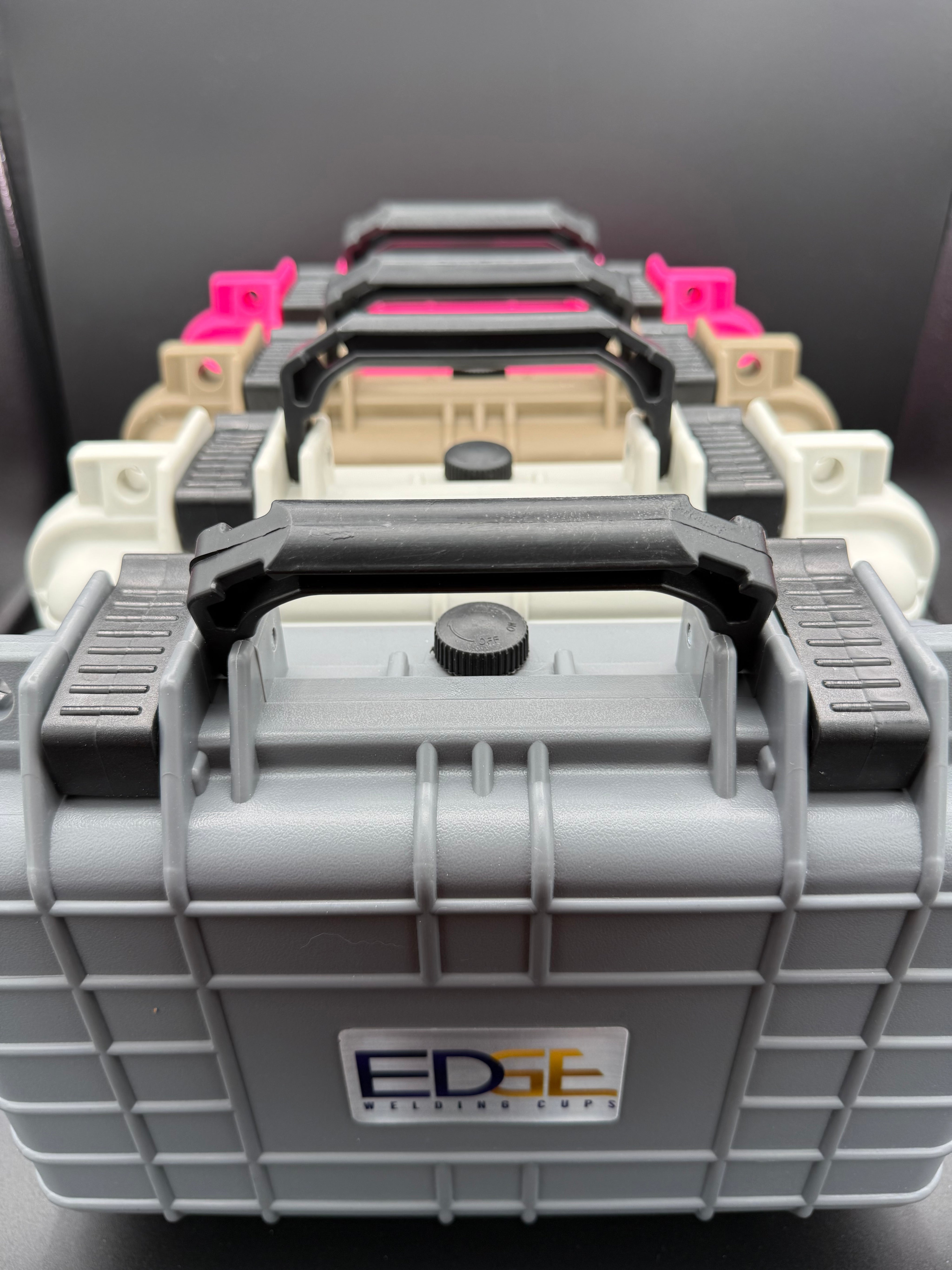 Stacked protective welding supply cases with handles in various colors, front view