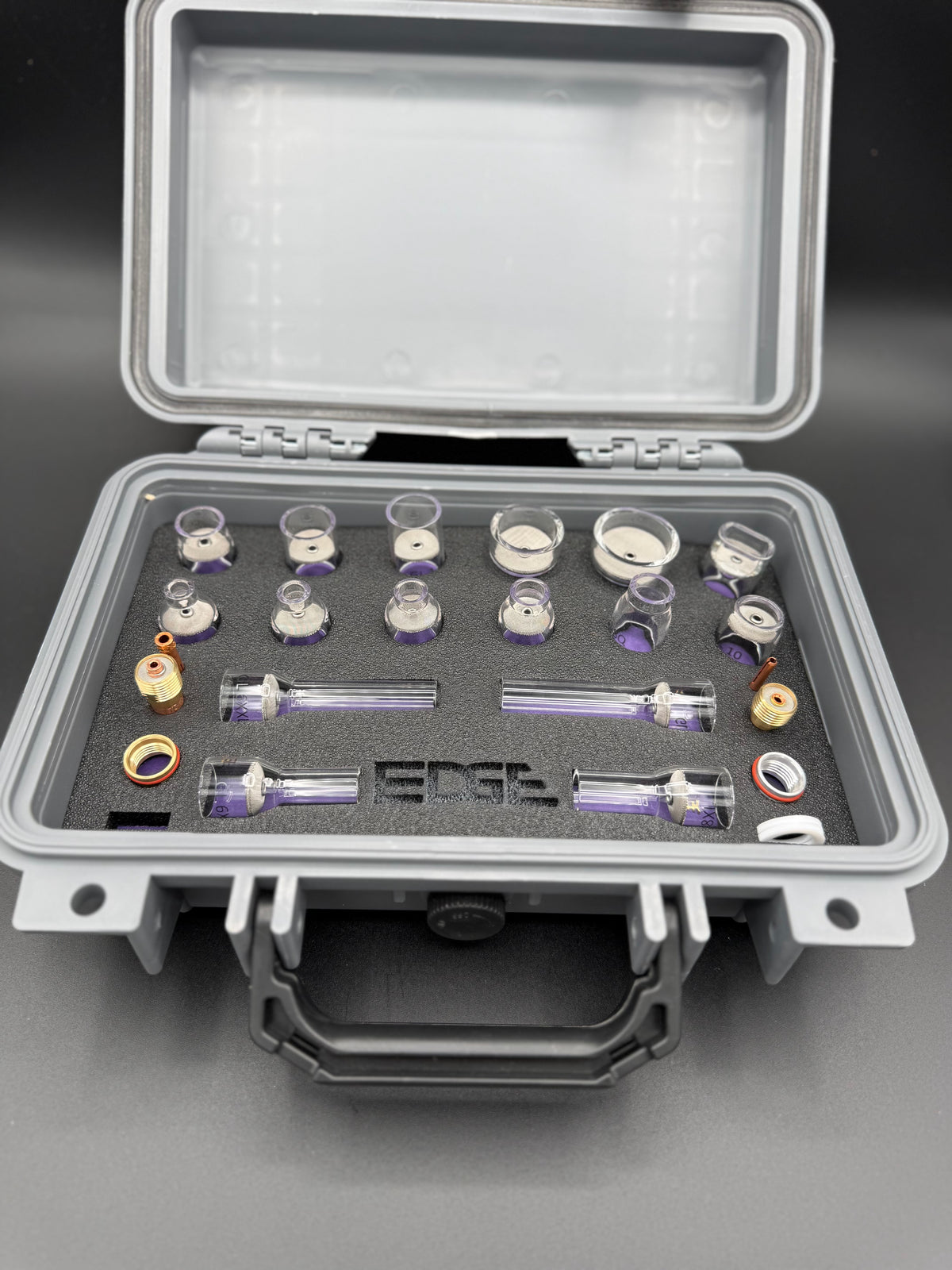Welding cup kit with glass cups and metal fittings arranged in a foam case